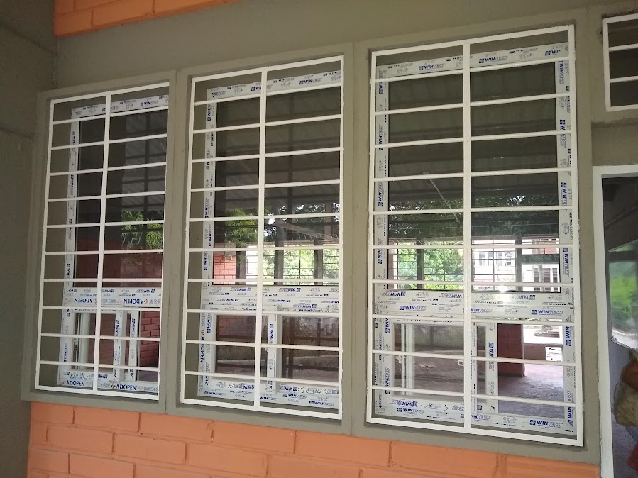 Ventanas en PVC con reja de seguridad en fachada de ladrillo – Clínica – ventanas hospitalarias en PVC