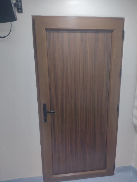 Puerta de habitación hospitalaria en PVC con acabado madera – Clínica Altos de San Vicente