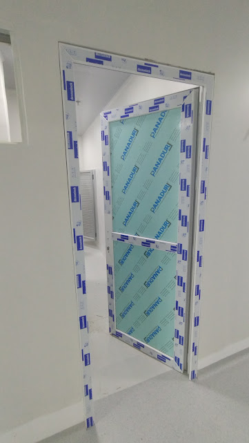 Puerta en PVC con película protectora recién instalada – Edificio Multifuncional – Universidad de Sucre
